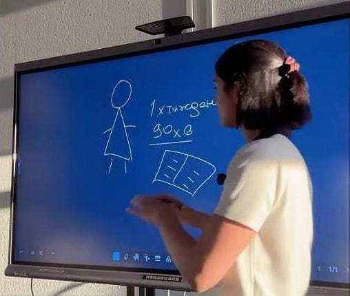 Maria am digitalen Whiteboard: sie zeichnet und rechnet vor, wie viele Stunden pro Woche zusammenkommen